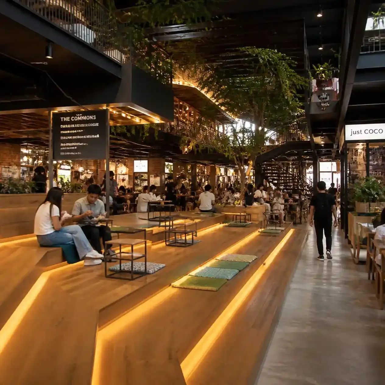 Tiered wooden seating and open-air food stalls at The Commons community mall in Thonglor, Bangkok