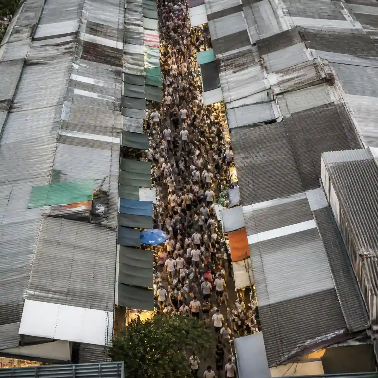 Aerial view of the corrugated metal roofs and crowded narrow alleys of Chatuchak Weekend Market in northern Bangkok