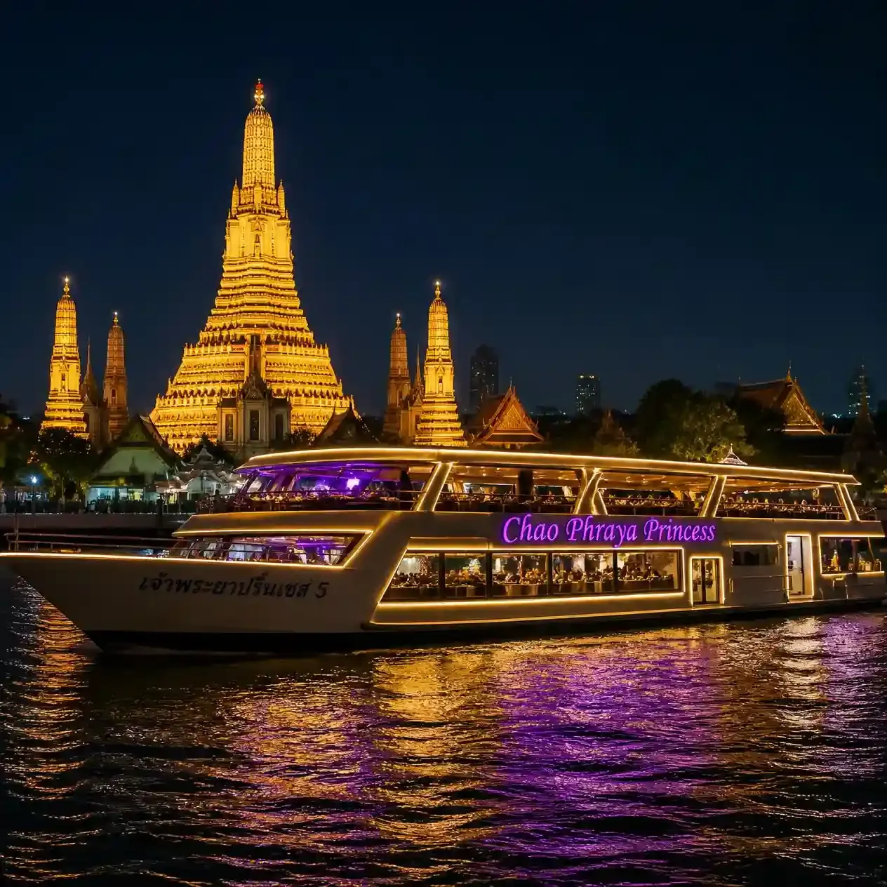 The Chao Phraya Princess dinner cruise boat lit up at night on the Chao Phraya River with Wat Arun glowing behind it in Bangkok