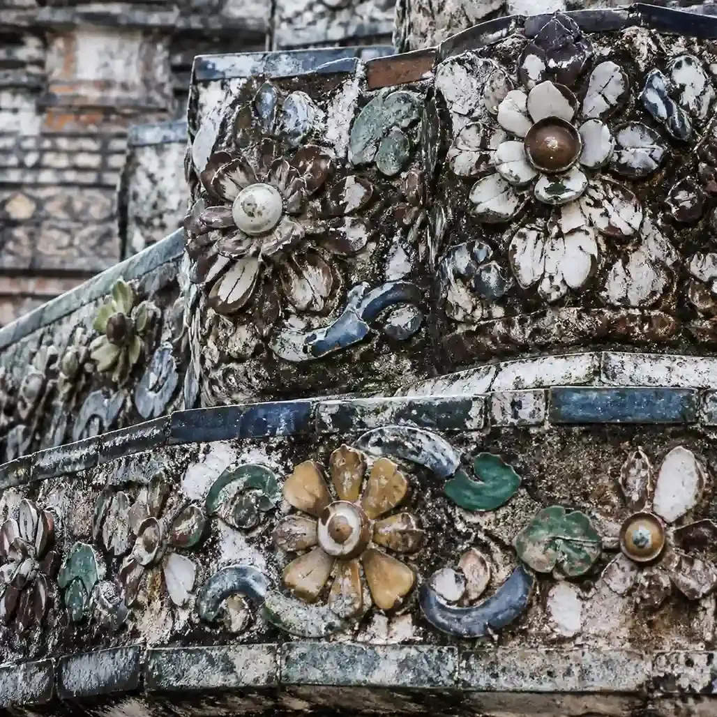 Close view of coloured porcelain fragments arranged into floral patterns on the prang at Wat Arun Bangkok
