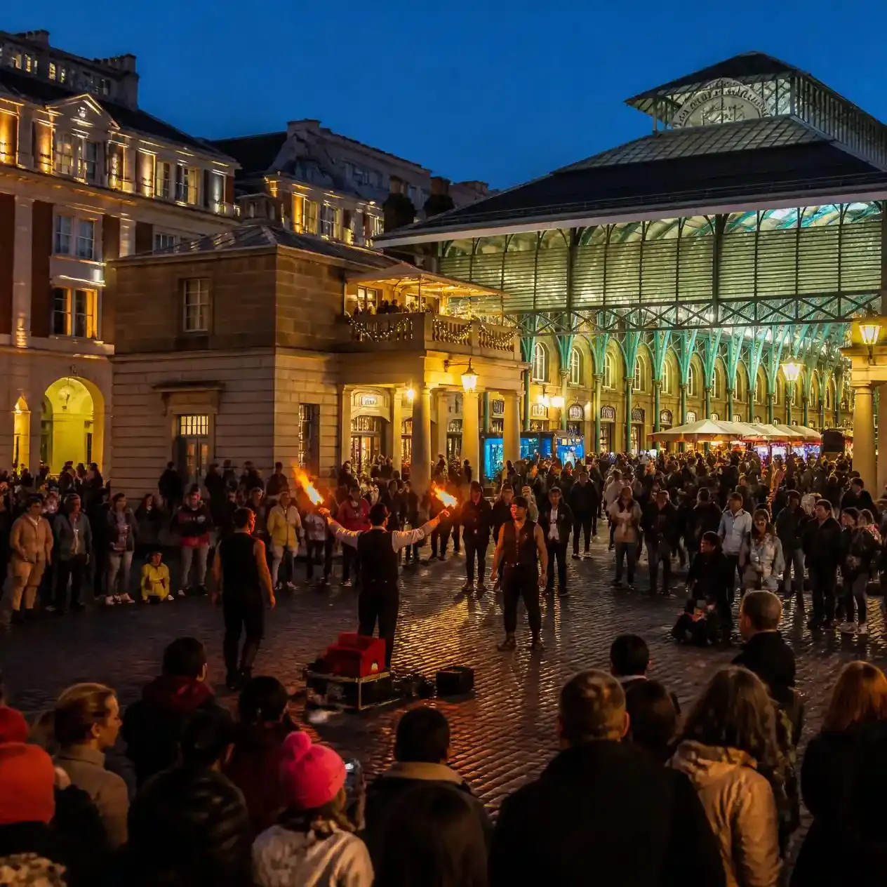Covent Garden piazza in the evening near the Novello Theatre with lit-up buildings and people dining outdoors