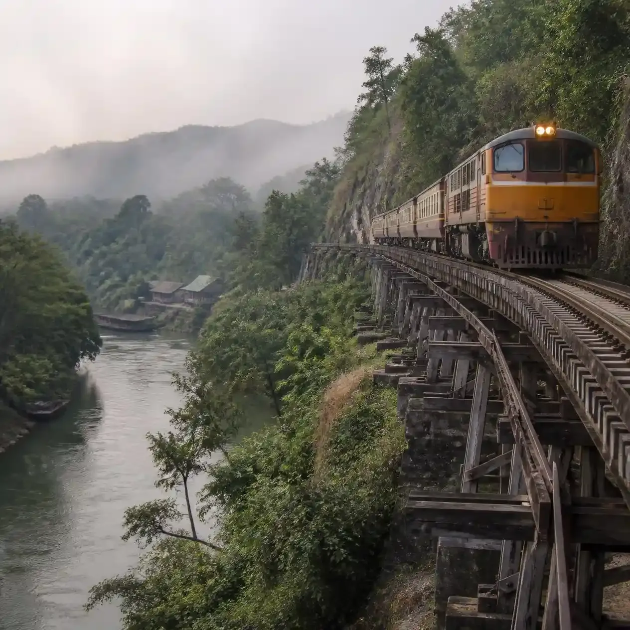Death Railway train crossing the wooden Tham Krasae viaduct above the river on a Bridge on the River Kwai tour from Bangkok