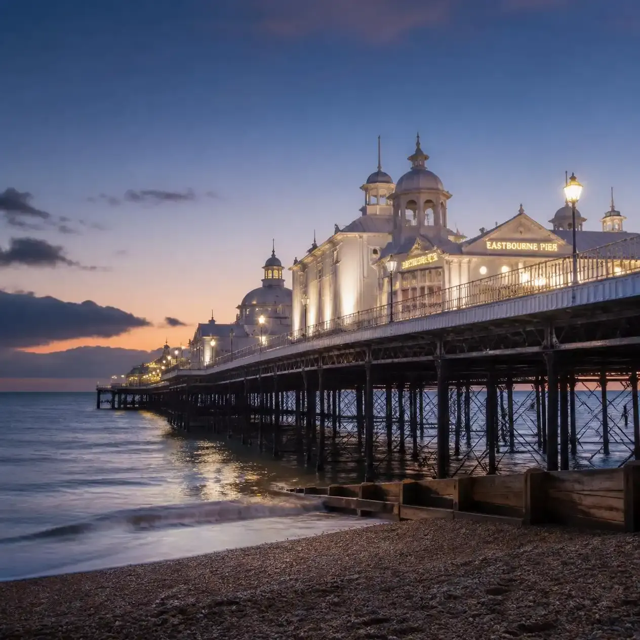 Eastbourne's Victorian pier with white domes illuminated at dusk on the East Sussex seafront