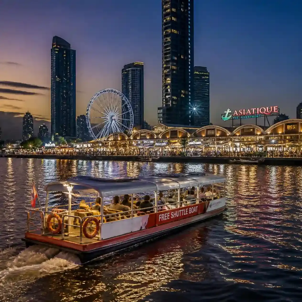 Free shuttle boat crossing the Chao Phraya River towards Asiatique Pier in Bangkok during the evening