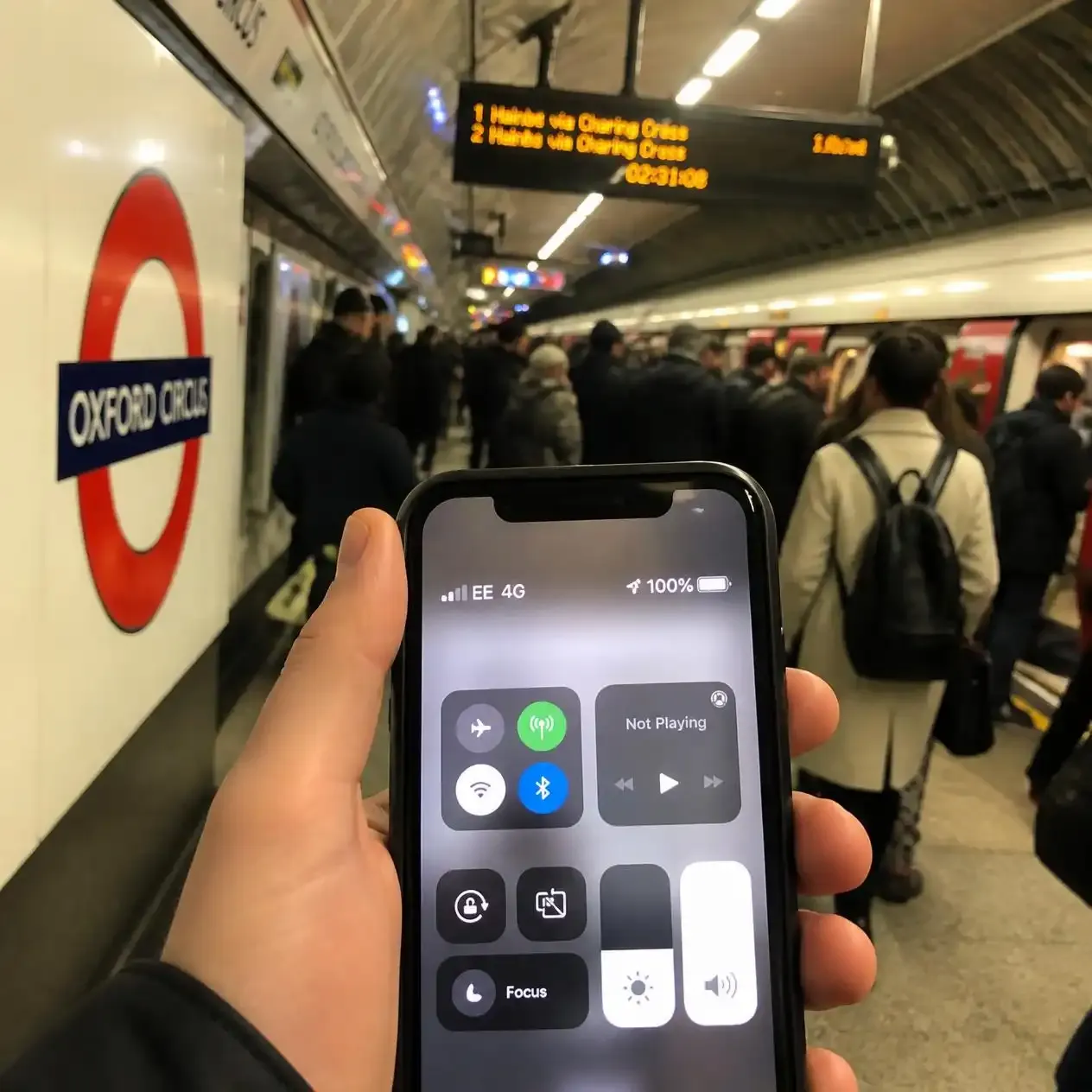 Smartphone showing mobile signal bars on a London Underground platform as part of the 4G and 5G Tube coverage rollout