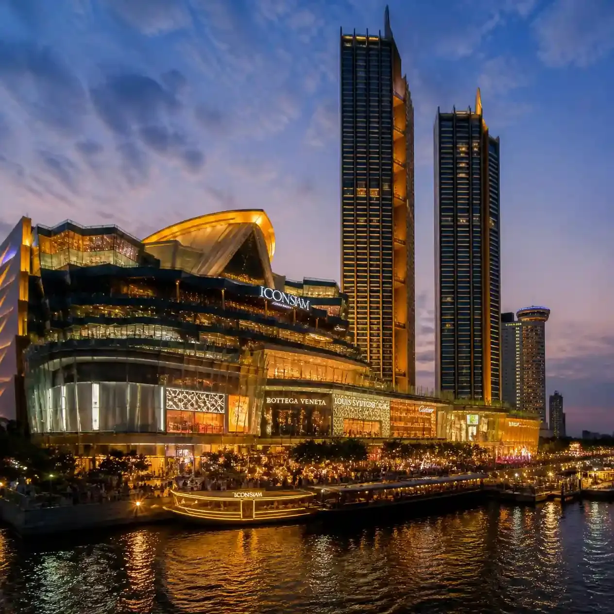 The ICONSIAM shopping complex lit up on the Chao Phraya riverfront in Bangkok during blue hour