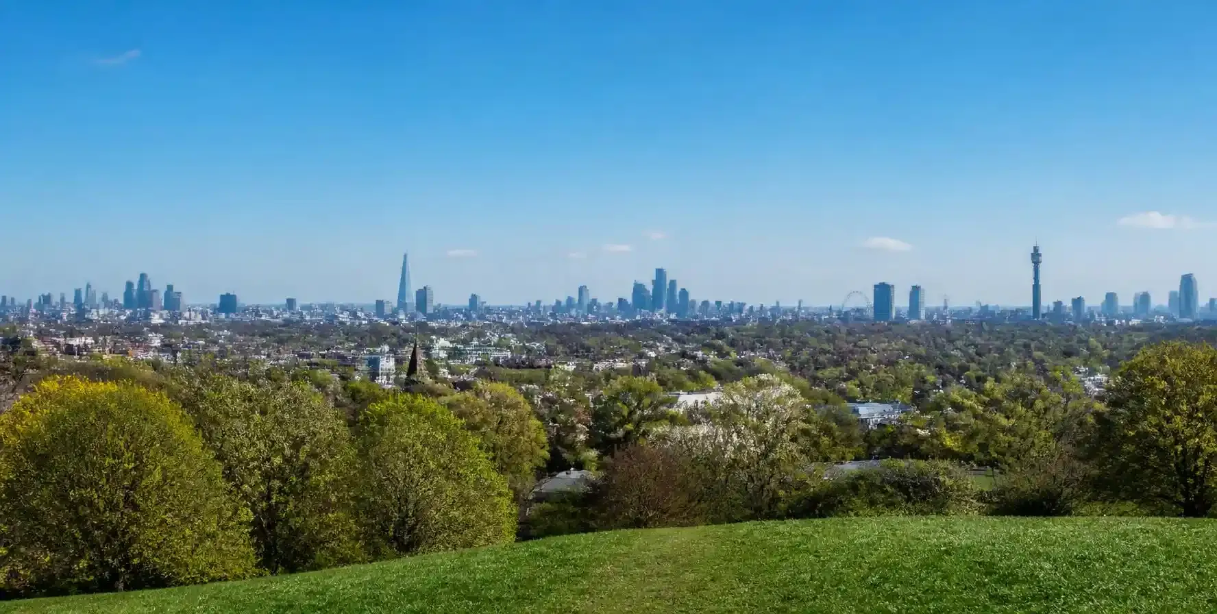 View across the London skyline from Parliament Hill on Hampstead Heath, with the city clusters in the distance