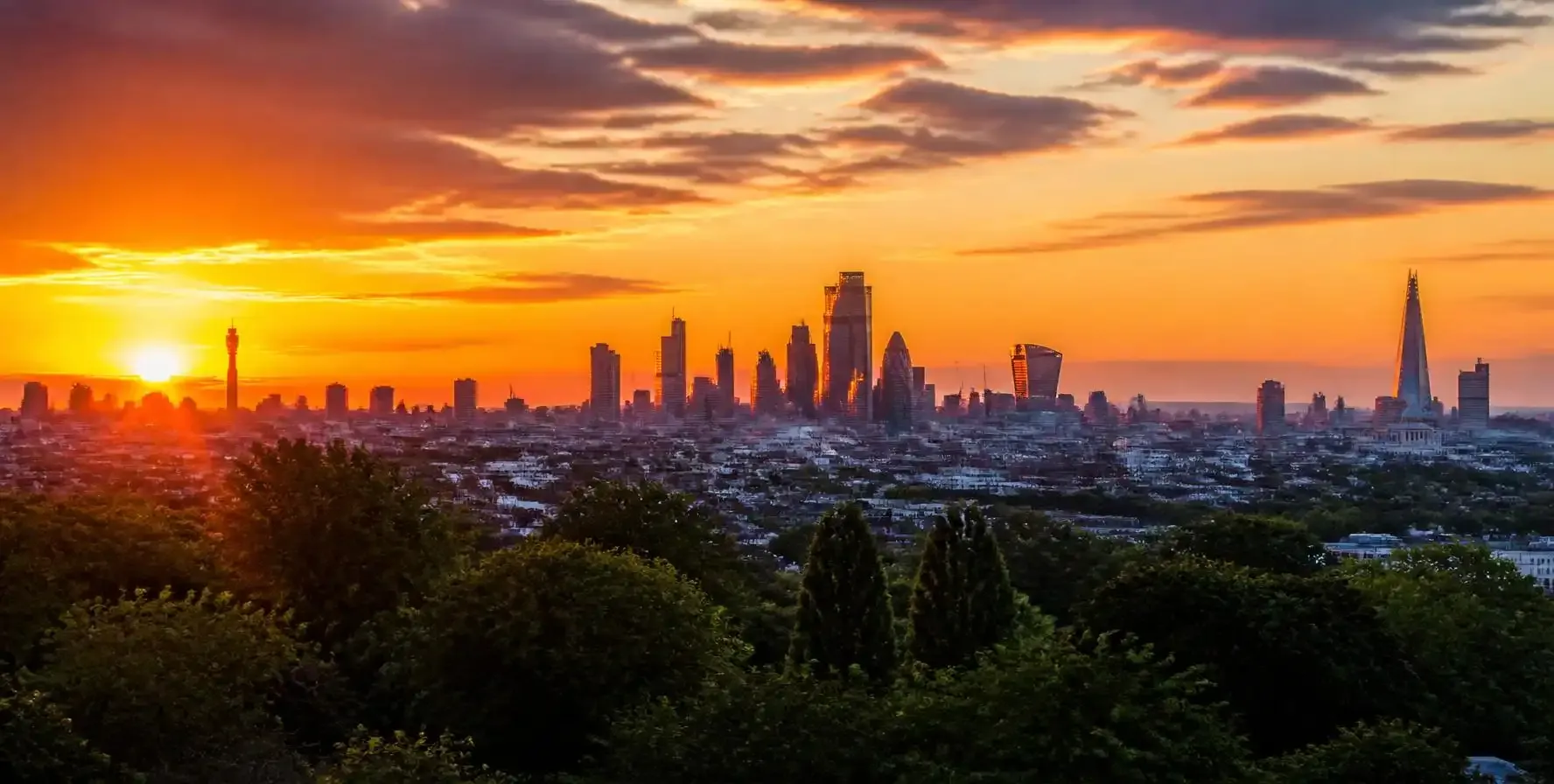 View of the central London skyline including the Shard and BT Tower from the top of Primrose Hill in London at sunset