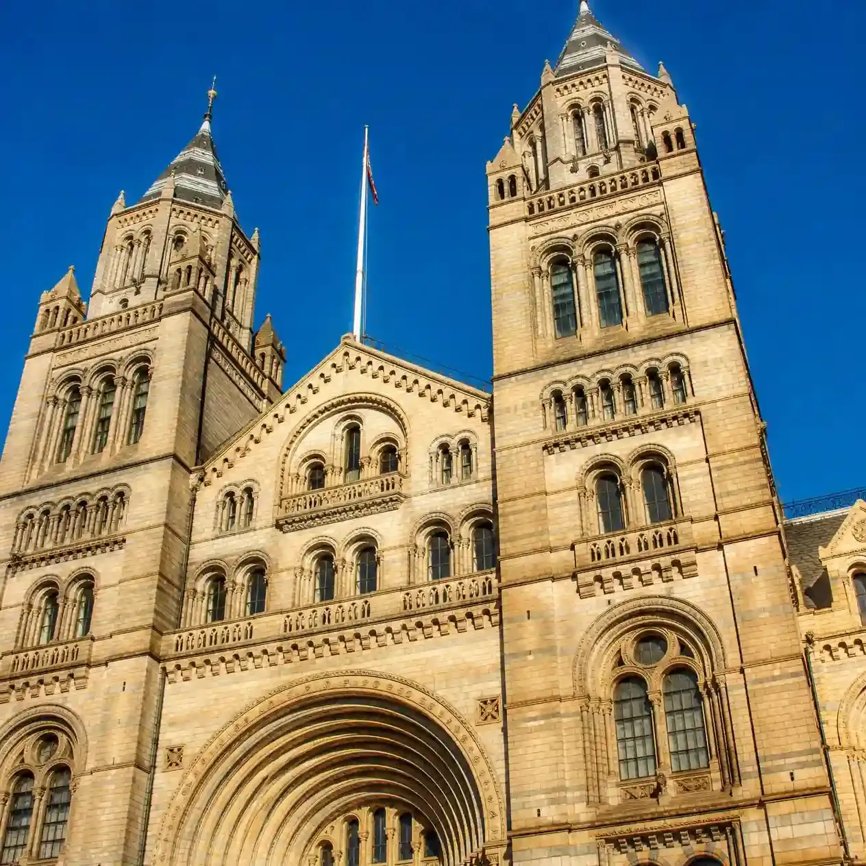 The terracotta towers and arched Romanesque facade of the Natural History Museum in South Kensington, London