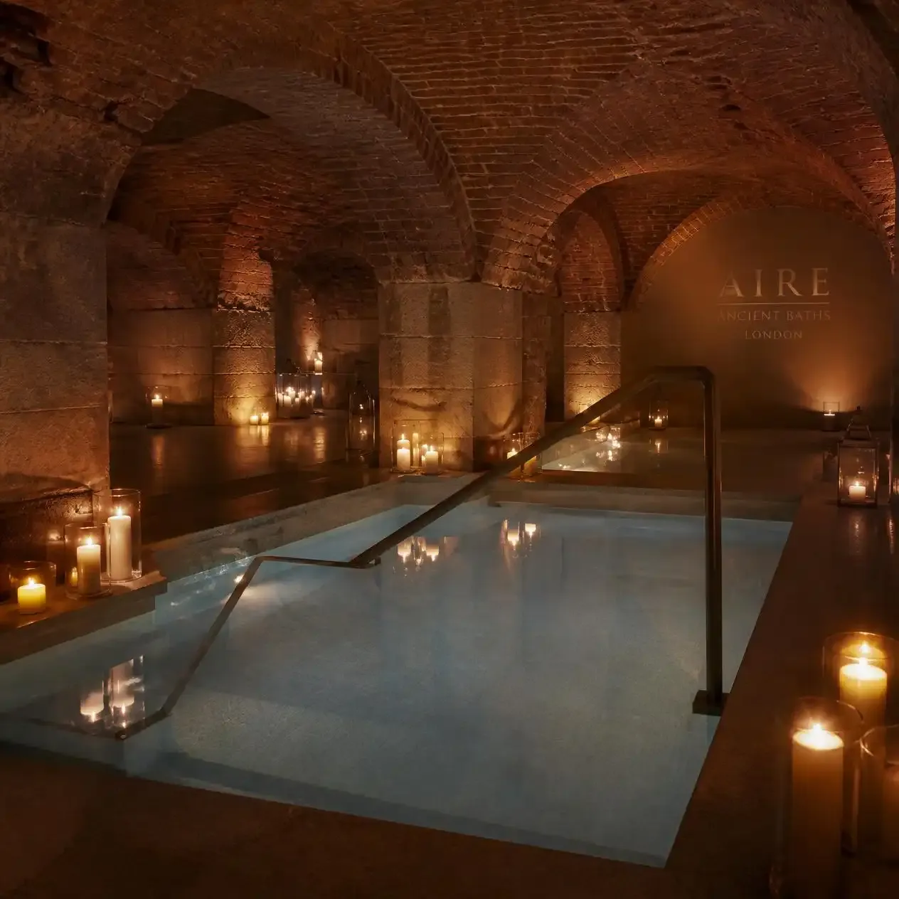 Guest floating in the candlelit salt-water flotarium at AIRE Ancient Baths London, a candlelit thermal baths London experience