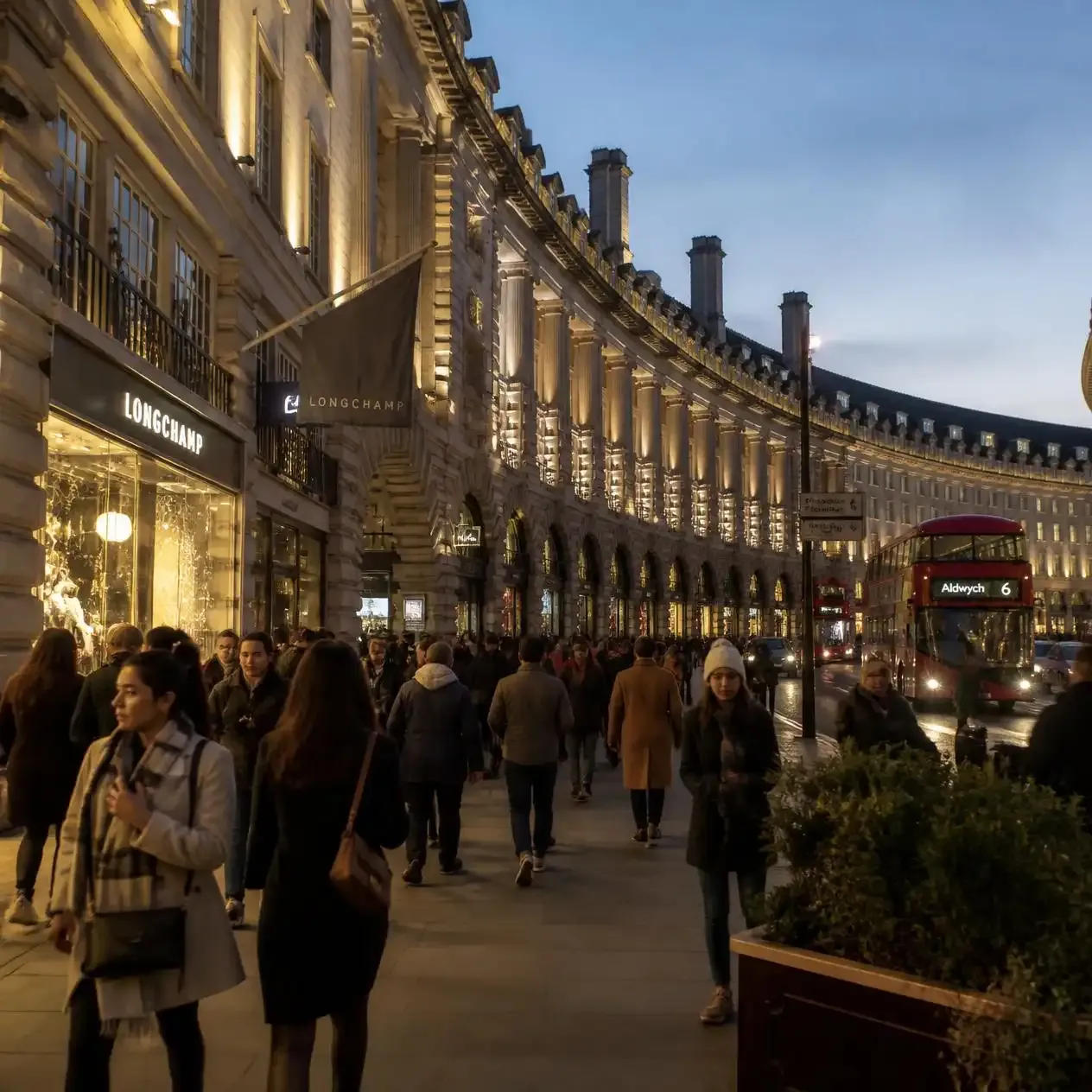 Shoppers walking beneath the curved Edwardian facades of Regent Street in London's West End