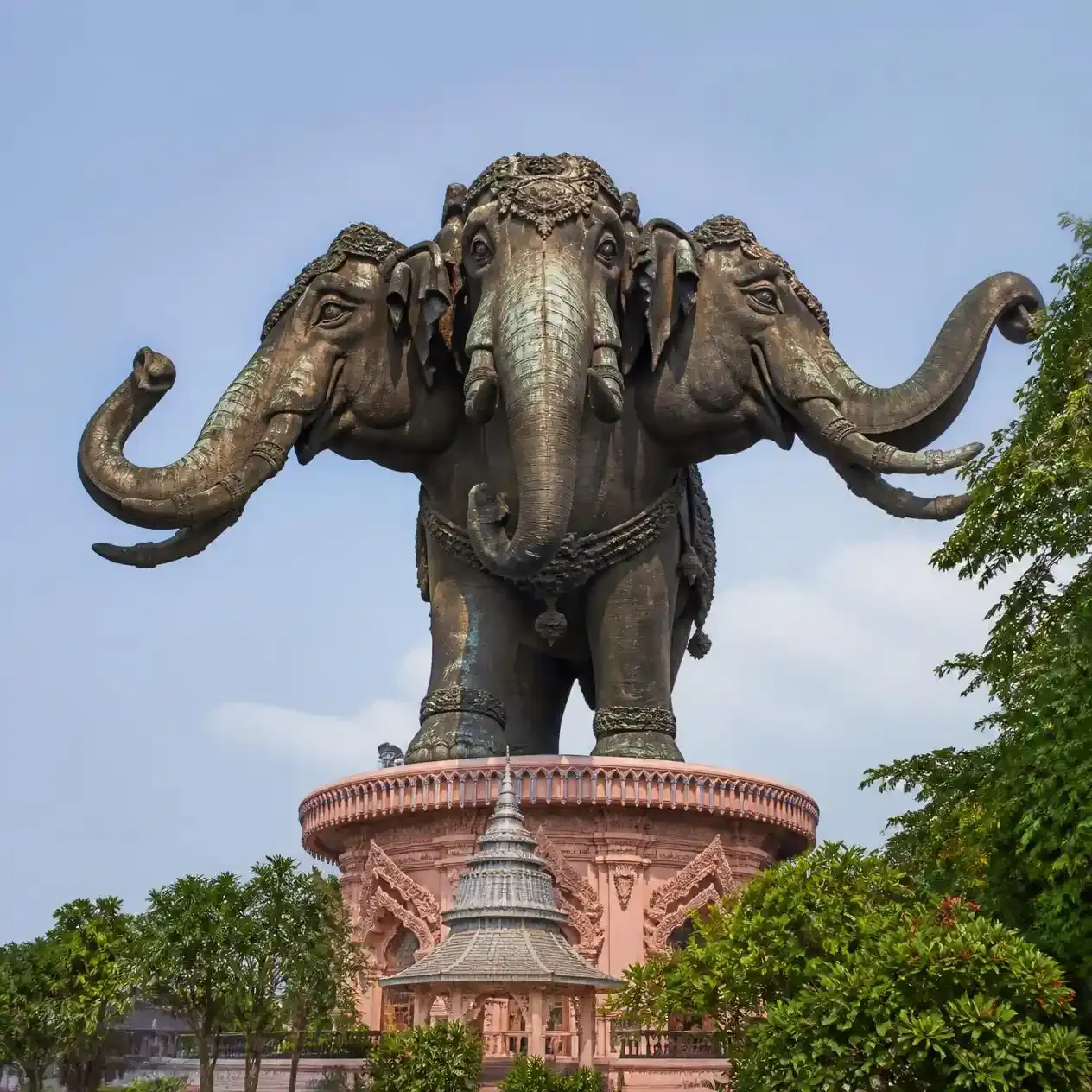 The three-headed bronze Erawan elephant statue rising above the pink museum building in Samut Prakan near Bangkok