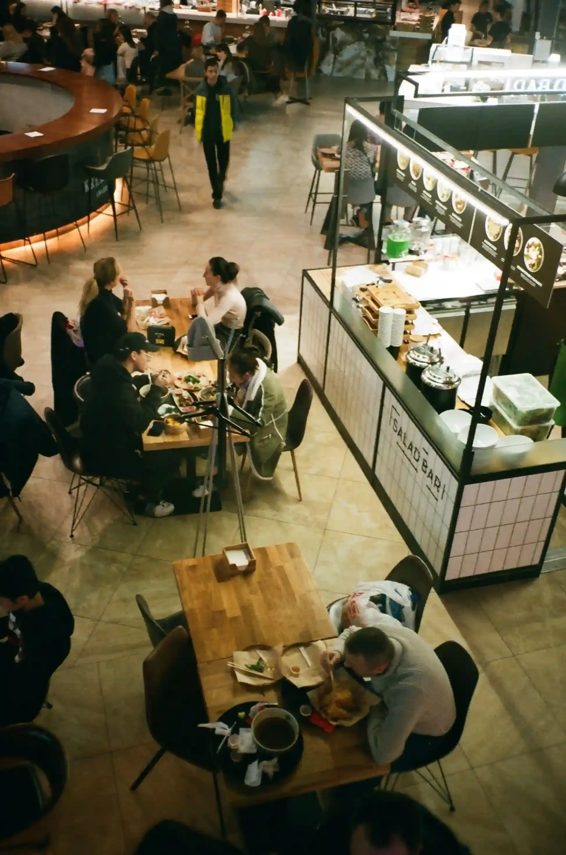 Shared tables and street-food stalls inside the Mercato Metropolitano food hall in London at dinner time