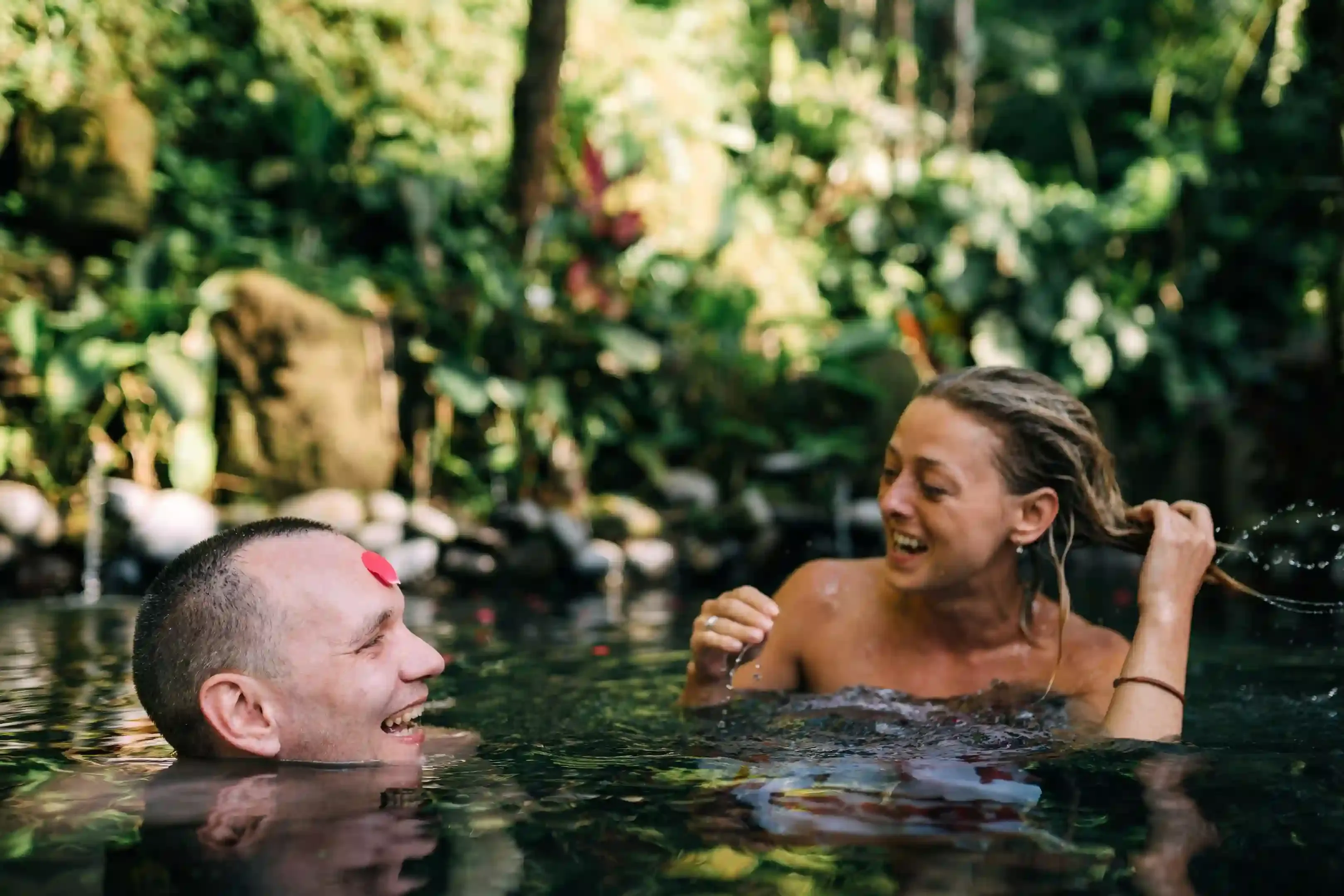 Couple at the Hampstead Heath bathing ponds surrounded by trees on a summer morning in London