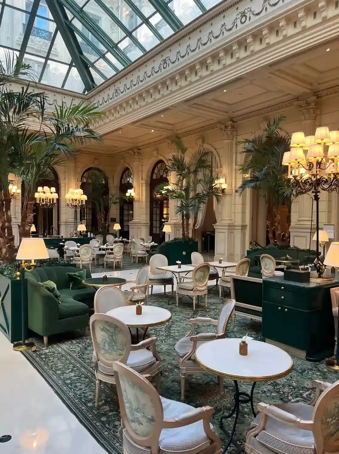 Grand London hotel tea room with gilt ceiling and tables set for afternoon tea in the Palm Court style