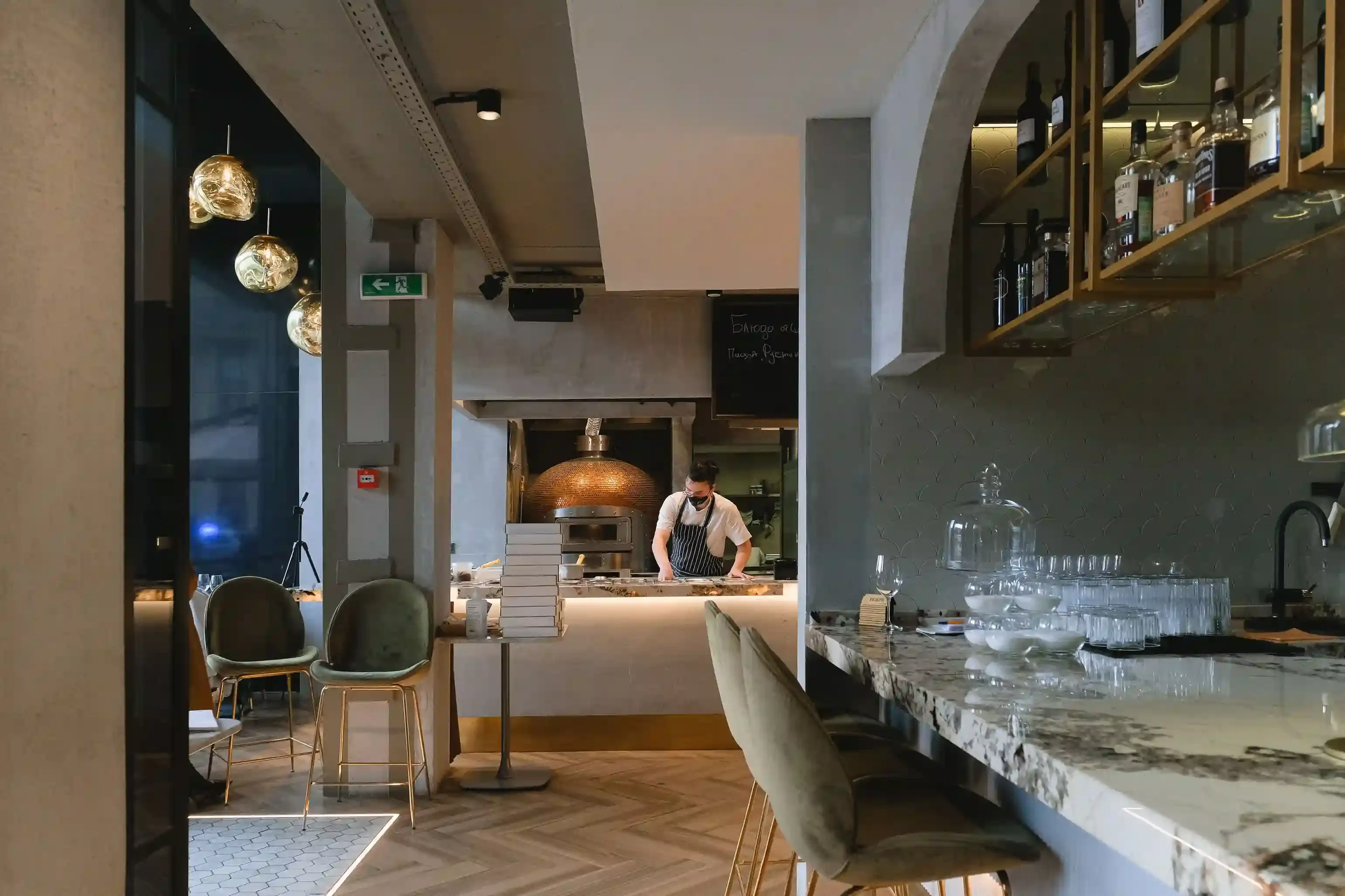 Diners at the open kitchen counter of a small-plates and natural-wine bar in Shoreditch, one of the trendy places to eat in London