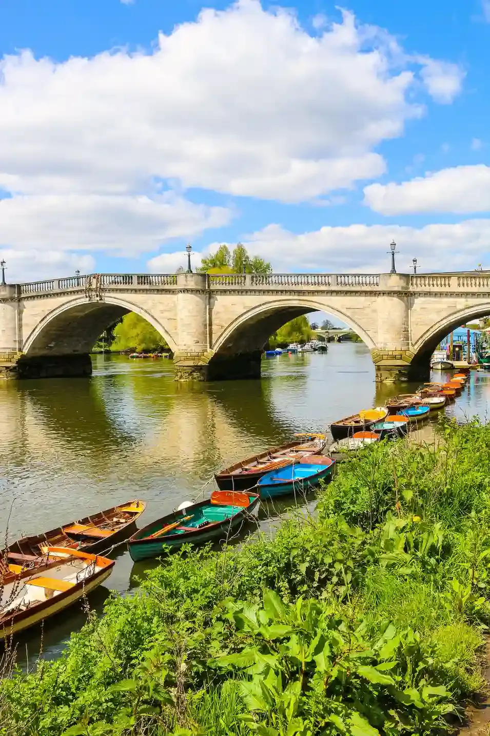 Boats moored along Riverside Walk beside Kingston Bridge on the River Thames in Kingston upon Thames