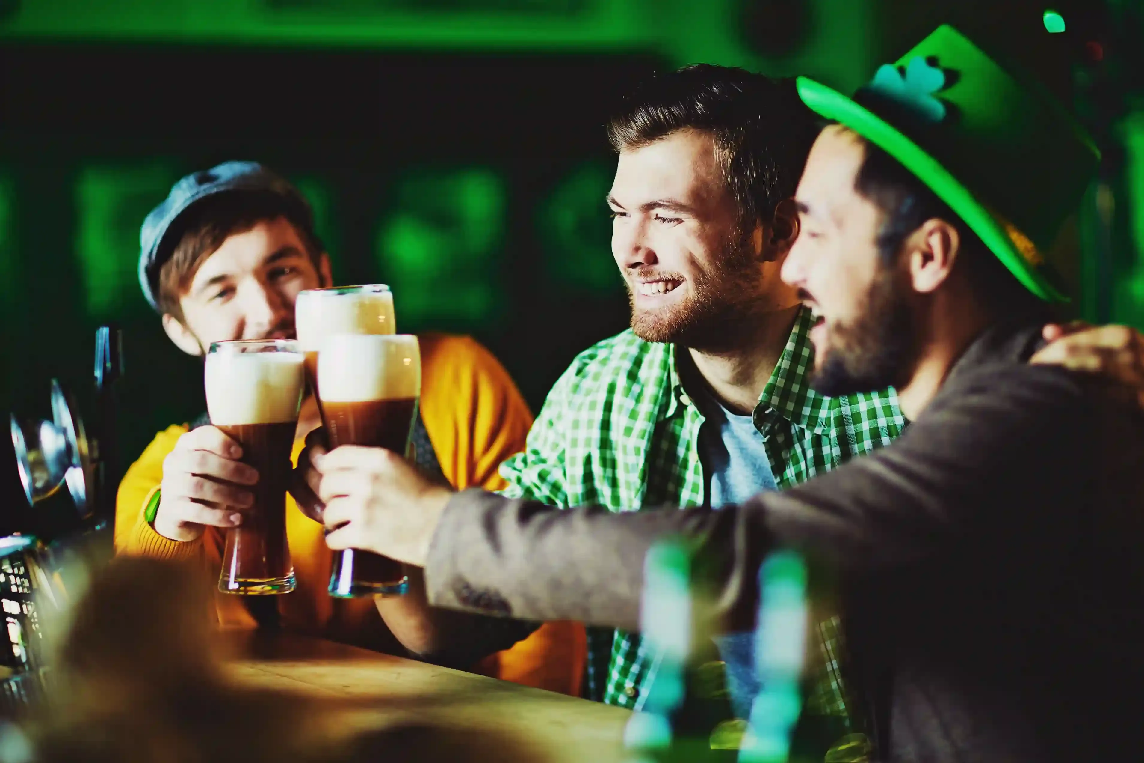 Friends raising pints inside a crowded traditional pub during a London pub crawl in Soho