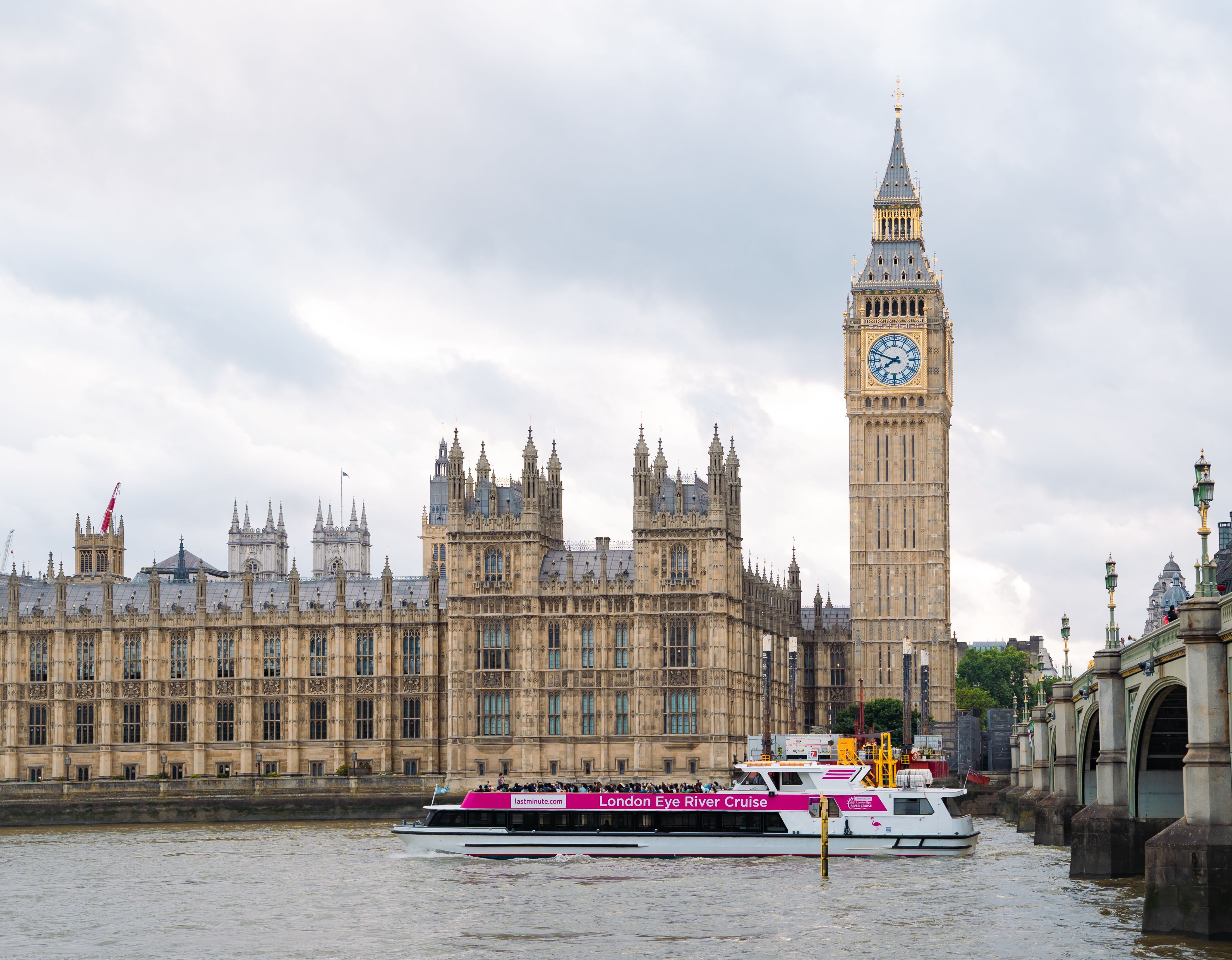 A Thames sightseeing cruise boat passing Big Ben and the Houses of Parliament on a London river cruise