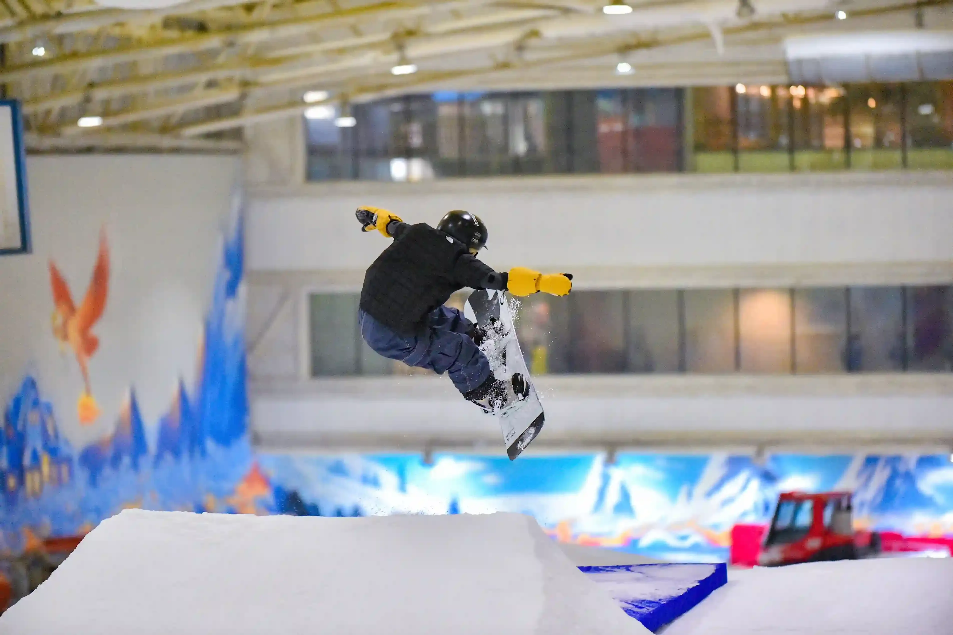 Skiers and snowboarders riding the indoor real-snow slope at Big SNOW inside the American Dream mall