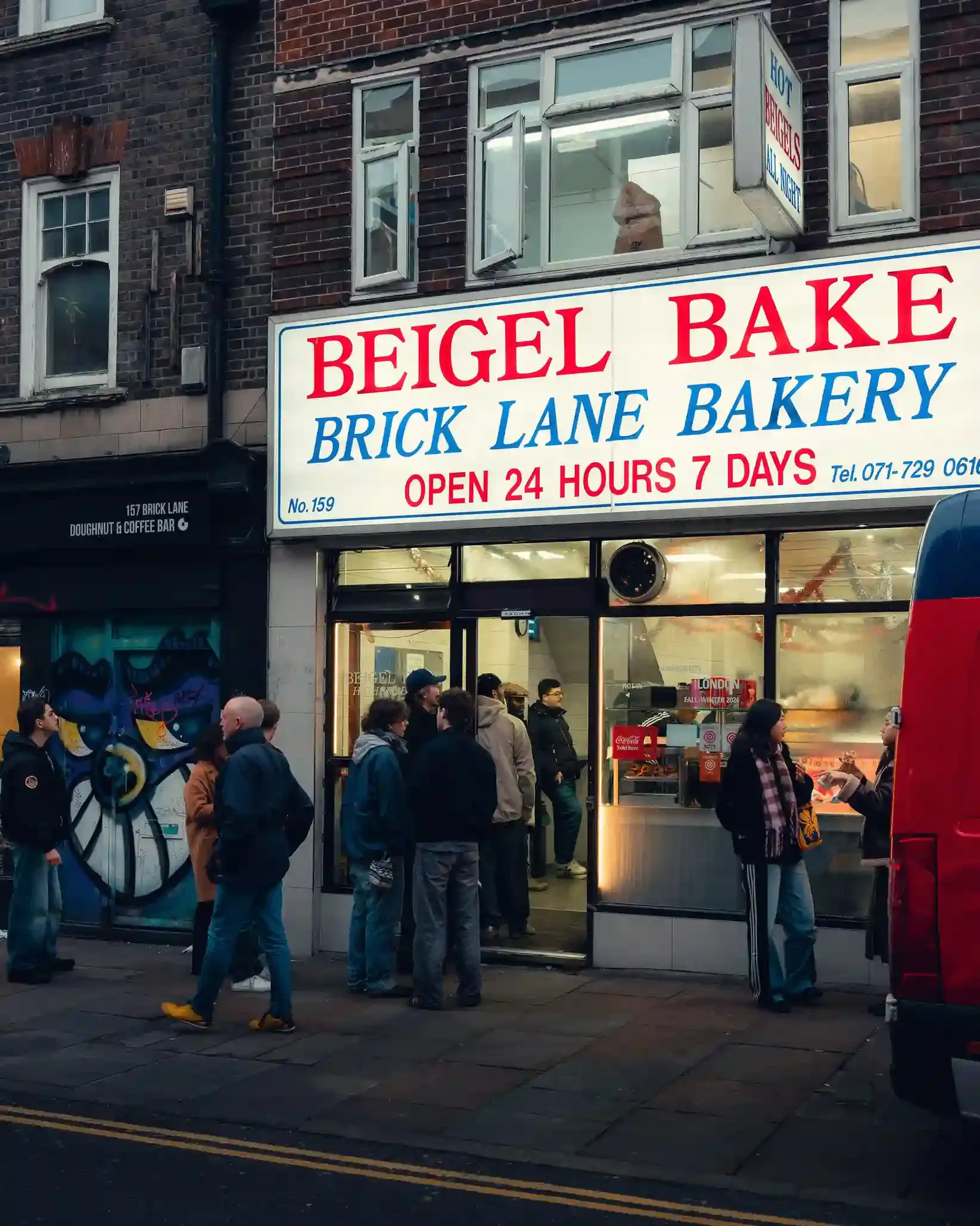 Small group on a food tour tasting salt-beef beigels on Brick Lane in London's East End