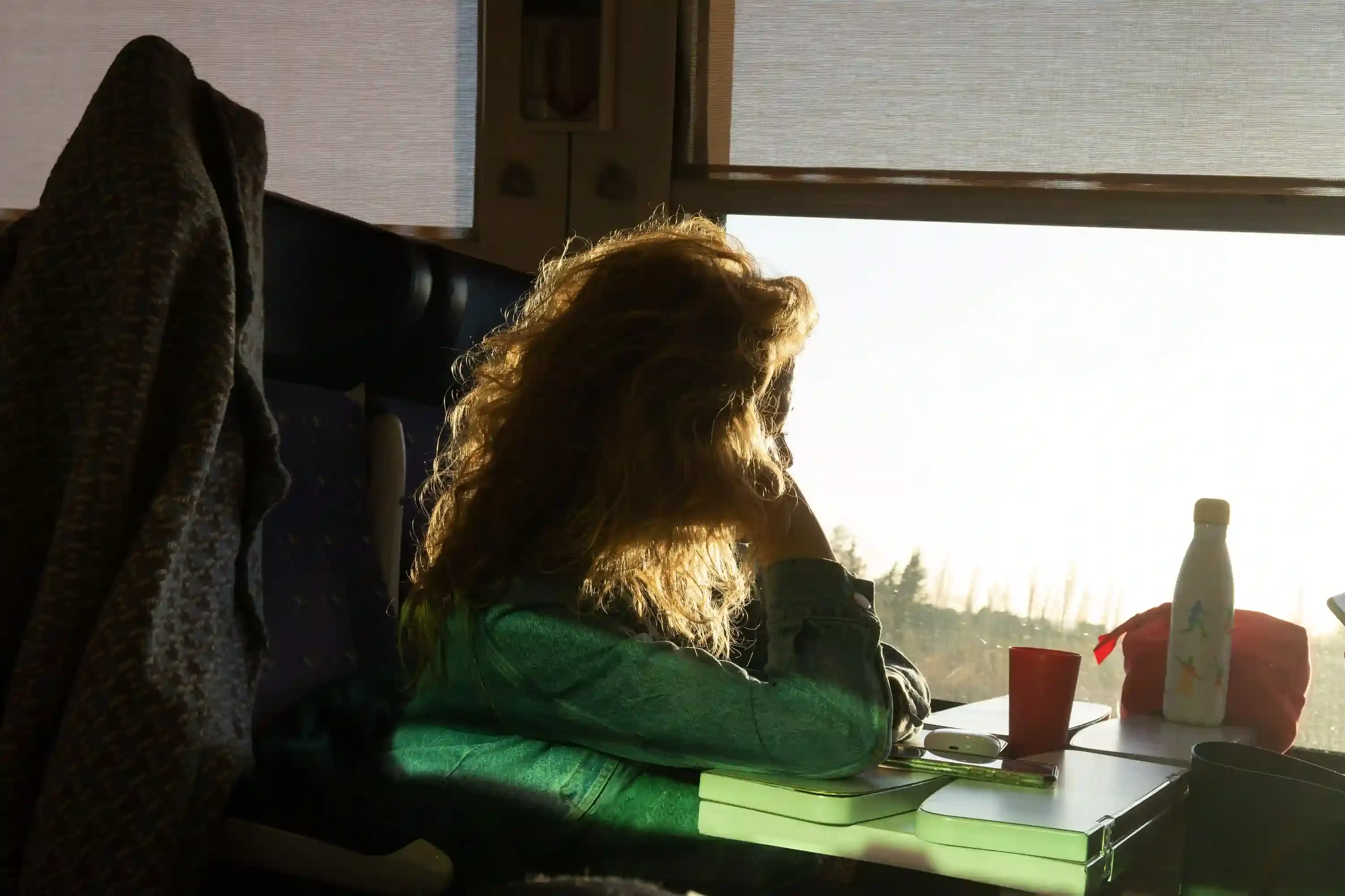 Solo traveller watching the English countryside from a train window on a day trip from London