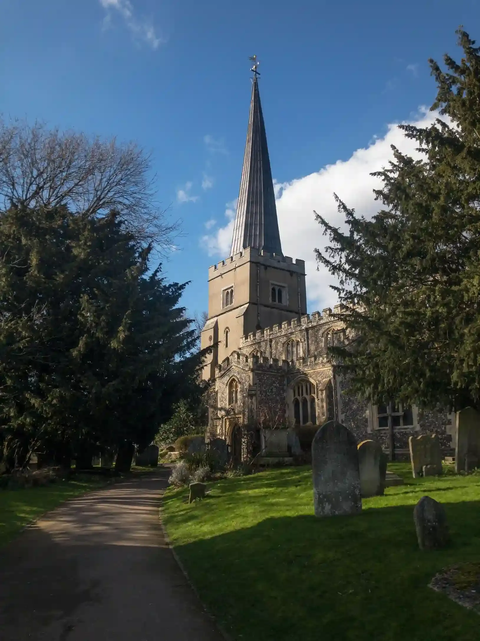 The spire of St Mary the Virgin Church rising above the tree-lined Church Green in Witney in the Oxfordshire Cotswolds