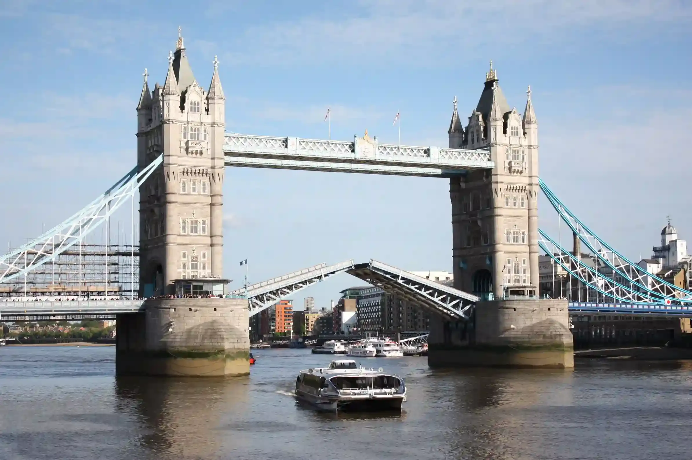 Thames dining cruise passing a lit Tower Bridge at dusk on a romantic evening in London