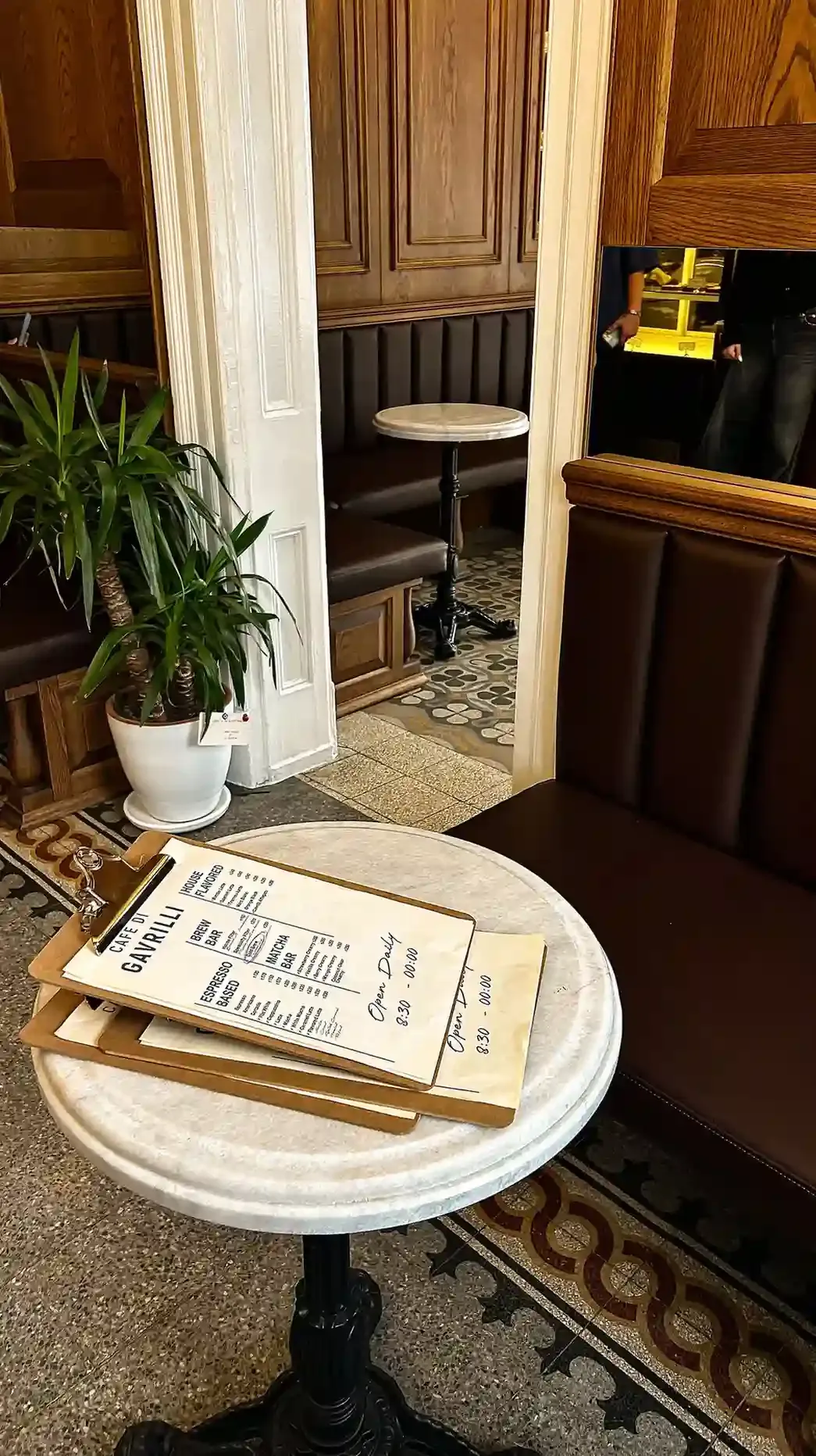 Marble-topped tables and white-tiled walls inside a traditional London pie and mash shop